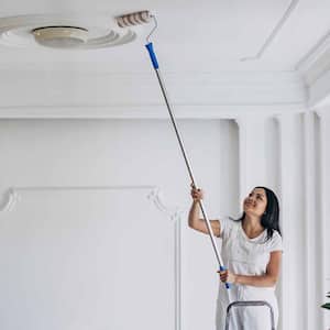 woman on ladder painting ceiling 