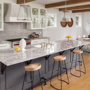 A beautiful kitchen with granite countertop and glass fronted cabinets 