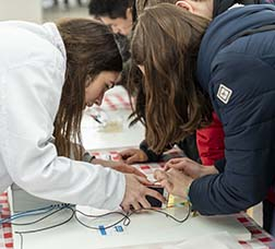 Joves científiques connectant uns cables a un mòbil per a fer un experiment