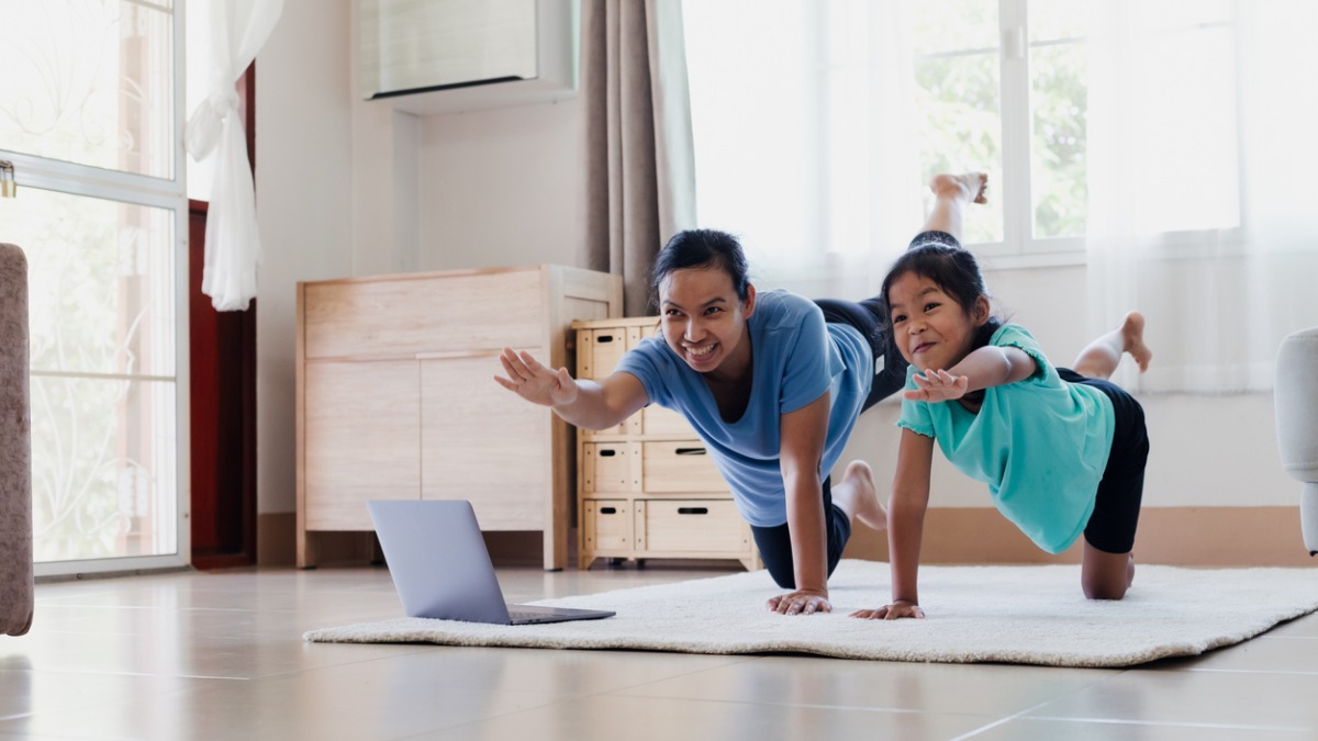 Child and adult doing yoga as out of school time physical activity 