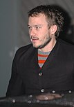 Young man with short beard, looking past the camera