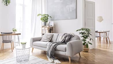 A living room with a dining area in the background