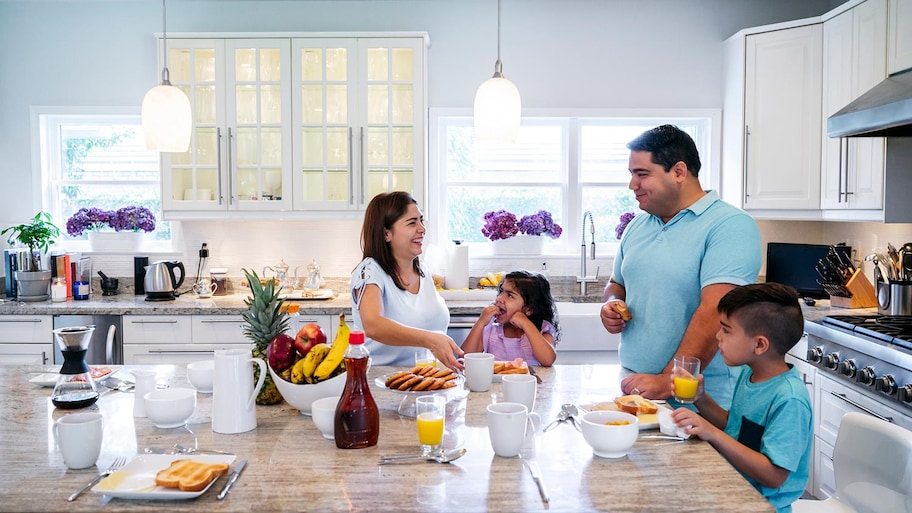 Family enjoys preparing breakfast in kitchen