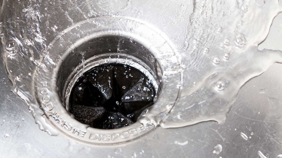 Stainless steel kitchen sink with water running