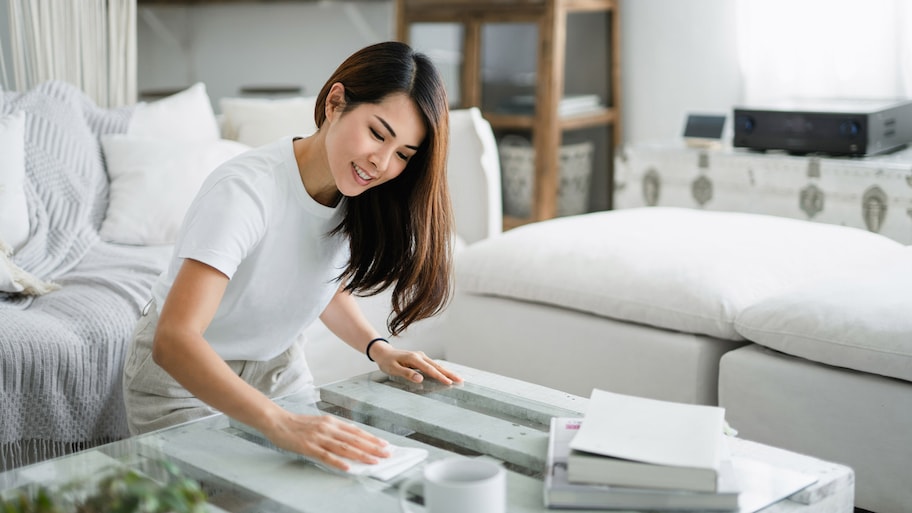 A woman dusting a coffee table