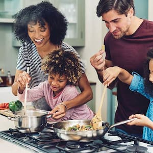 Family cooking together on gas stove