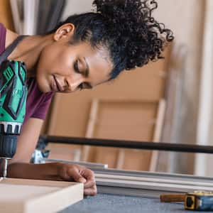 Woman using a drill in her workshop