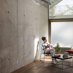 A woman in a home with concrete wall