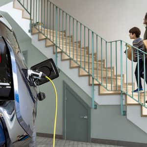 A mother and child in a garage with an electric car