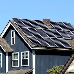 a blue house with roof covered in solar panels