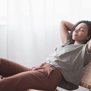 Woman sitting on a chair is relaxing by the window