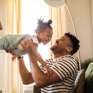 A father lifting toddler daughter in the air