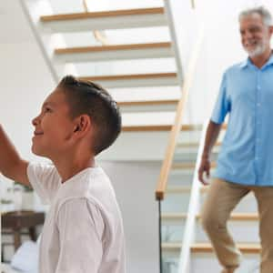 A kid adjusting the temperature of the house via a digital thermostat