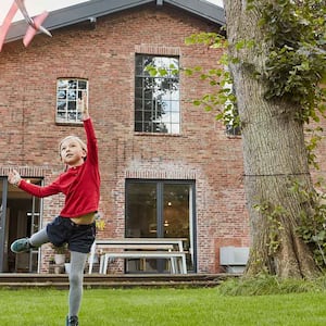 Children play in front of a brick house