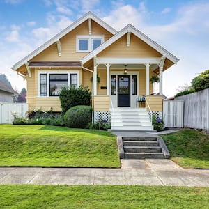 Craftsman-style house with yellow exterior paint and white accents