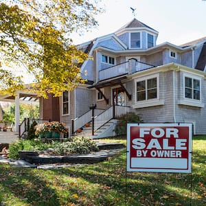 large house with for sale sign in front