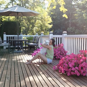 Woman sitting on a wood deck hugging her dog