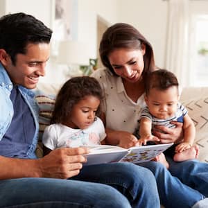 Young Hispanic family sitting on couch in living room