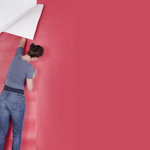 woman applying pink wallpaper