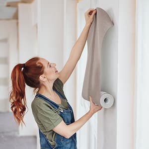 Young woman tries out a new wallpaper