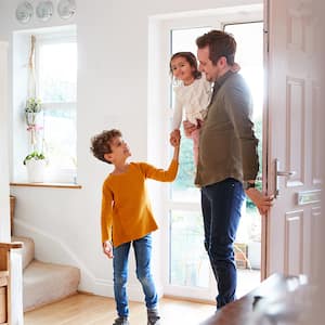 Family entering through the front door of home