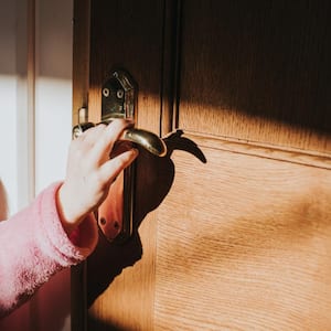 A little girl attempts to open a door