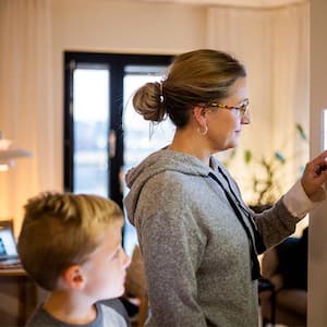 mother setting up security system with son