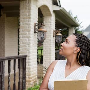 An appraiser stands in front of a house