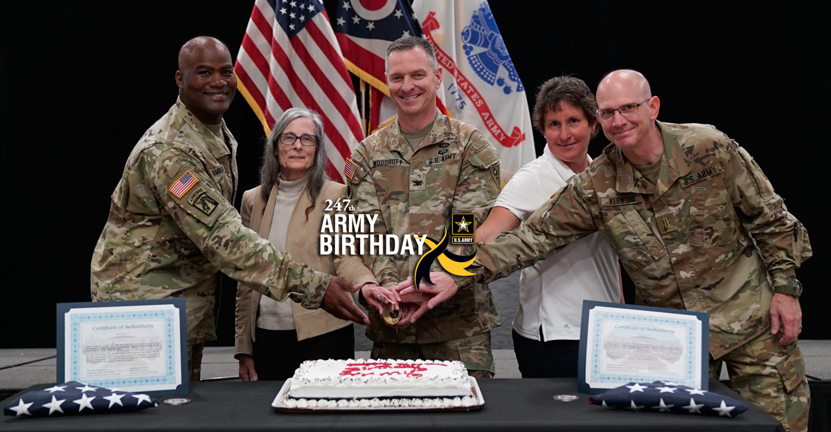 ONG leadership poses with sword to cut cake.