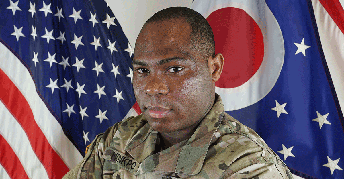 African-American Soldier in front of US and Ohio flags.