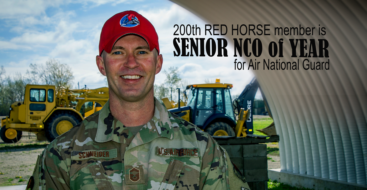 Senior Master Sgt. Mark Schneider with construction equipment in background