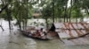 People get on a boat as they look for shelter during a widespread flood in the northeastern part of the country, in Sylhet, Bangladesh, June 19, 2022. 