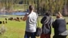 Visitors take pictures of a bison herd in the Hayden Valley in Yellowstone National Park, Wyoming, June 22, 2022.