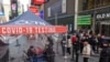 FILE - People wait to get tested for COVID-19 at a mobile testing site in Times Square on Dec. 17, 2021, in New York. 