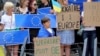 Protesters supporting of Ukraine's European Union integration stand with signs and EU flags during a rally outside of an EU summit in Brussels, June 23, 2022.