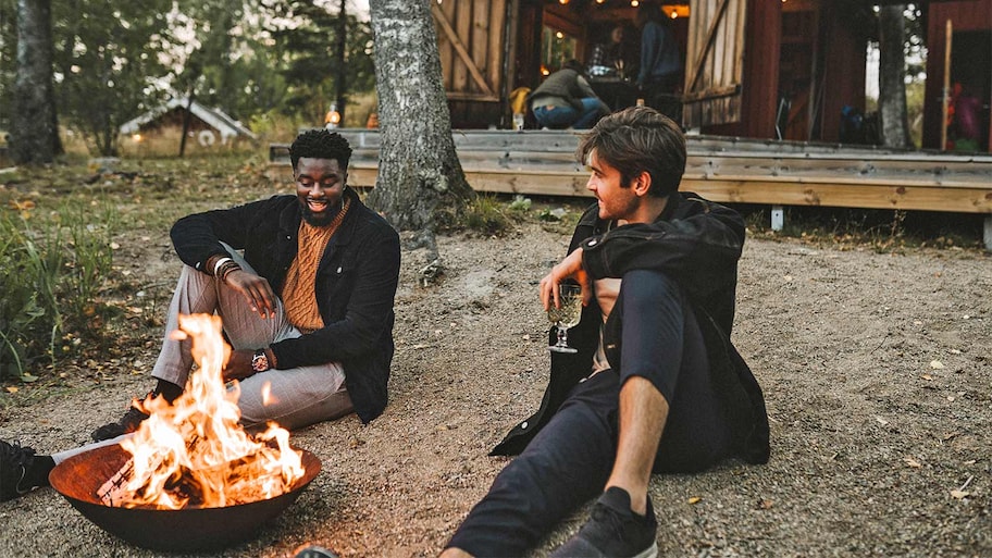 Men sitting by fire pit outside