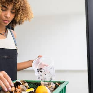 woman making compost from leftovers