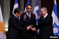 FILE - Cypriot President Nicos Anastasiades, Greek Prime Minister Kyriakos Mitsotakis and Israeli Prime Minister Benjamin Netanyahu pose for a photo before signing a deal to build a gas pipeline, in Athens, Jan. 2, 2020.