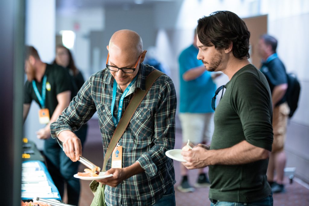 Two men grabbing snacks