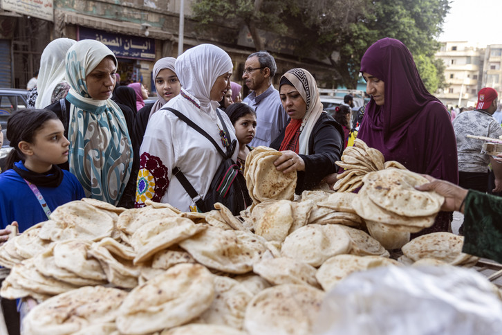 Women buy bread from a local bread stand in the Al Fustat neighborhood.