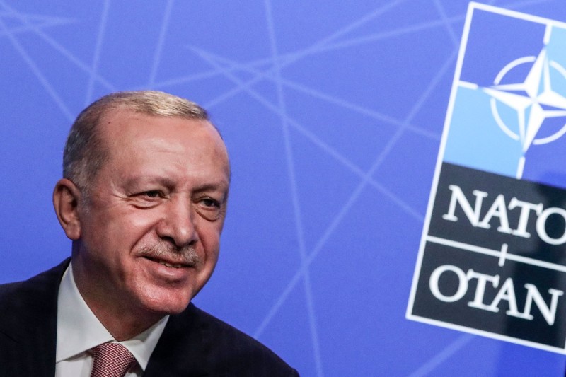 A close up of Erdogan's face is shown with the NATO logo behind it.