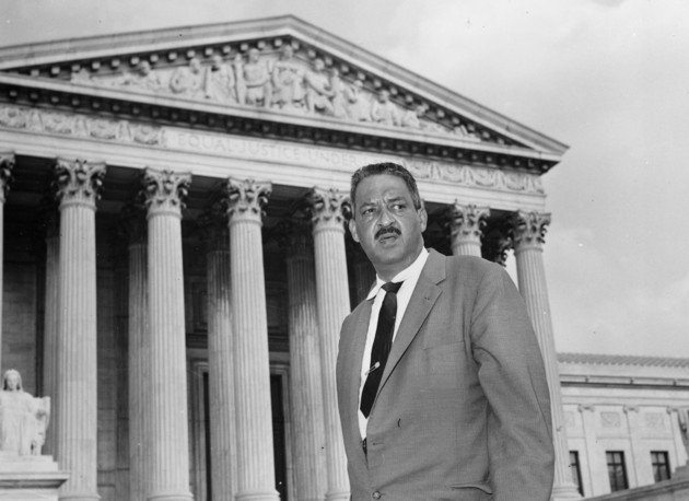 Thurgood Marshall stands outside the Supreme Court building in Washington.