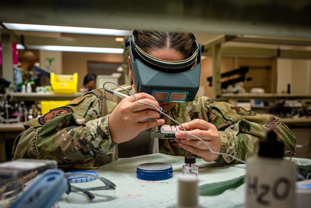 An Airman makes a wax mold for a tooth.