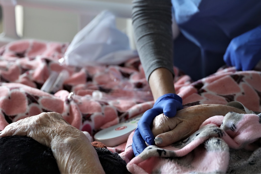 Nurse holding patient's hand.