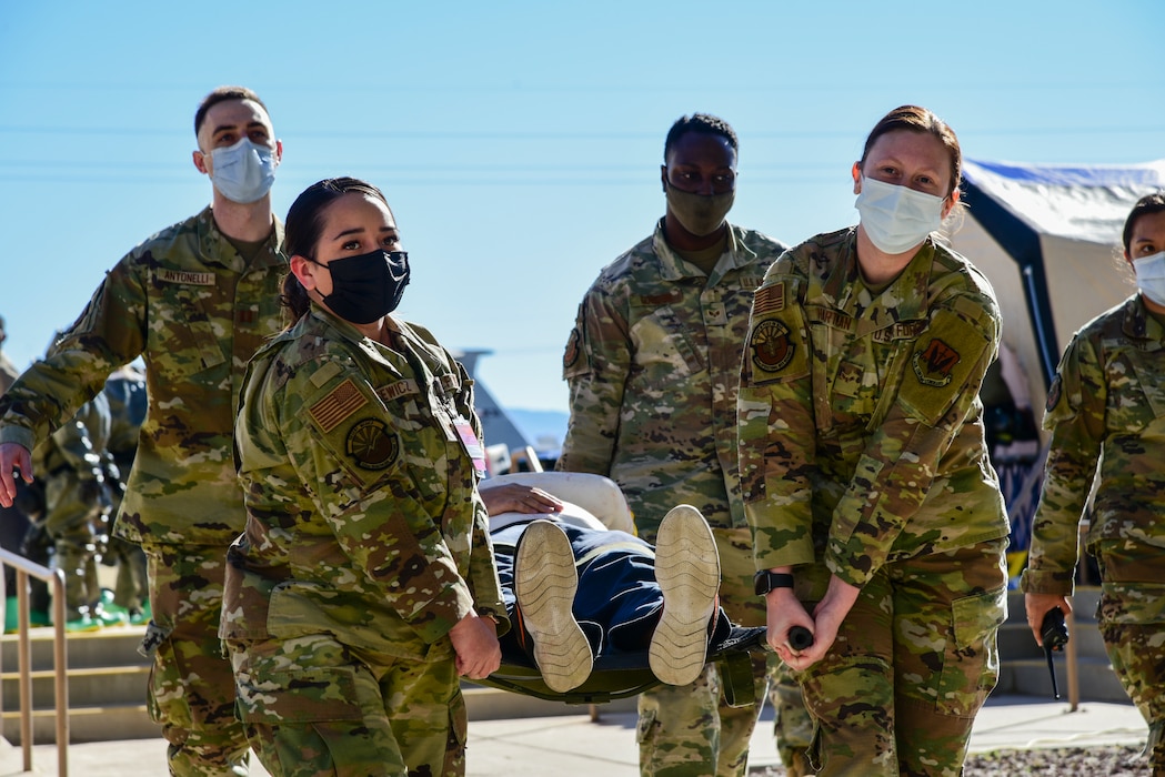 Image of Airmen carrying fake patient on gurney.