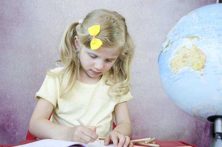 Girl writing on notepad.