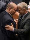 Israeli Prime Minister Naftali Bennett, left, and Foreign Minister Yair Lapid react after a vote on a bill to dissolve the parliament at the Knesset, Israel's parliament, in Jerusalem, June 30, 2022.