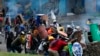 Protesters take cover behind makeshift shields during clashes with police in downtown Quito, Ecuador, June 24, 2022. The protesters are part of a national strike over economic issues, led by indigenous groups.