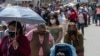 People queue for a free molecular testing and to be vaccinated at a makeshift health center on a street in downtown Lima on January 5, 2022.