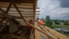 Civilians rebuild homes destroyed by Russian strikes, in Yahidne village, northern Chernihiv region, Ukraine, June 29, 2022. A few months after Russian troops retreated, people are repairing their homes, and a strong wind occasionally picks up the bitter smell of ashes.